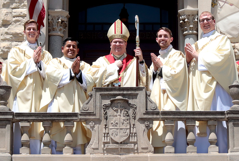 Following the Mass of Ordination on May 27 at St. Mary’s Cathedral in Peoria, Bishop Louis Tylka and the Diocese of Peoria’s four new priests gathered on the balcony of the Bishop’s Residence. They are (from left) Father Daniel Dionesotes, Father Ignacio Cárdenas Morán, Father Patrick Wille and Father Nathan Hopper. (The Catholic Post/Jennifer Willems)